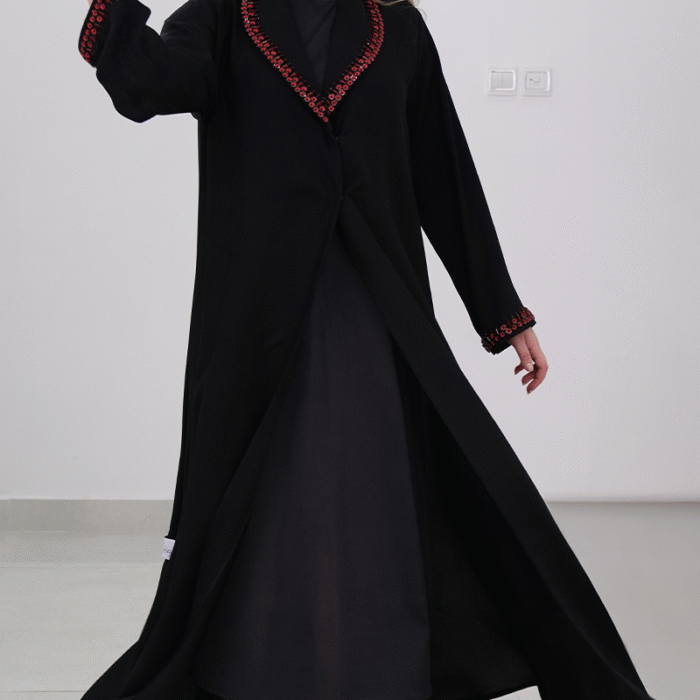 ⁦عباءة أنيقة باللون الأسود مع تطريزات حمراء مميزة⁩ - الصورة ⁦2⁩
